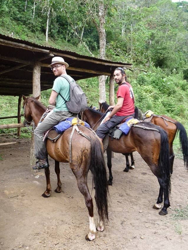 Deux hommes à cheval dans un boisé.