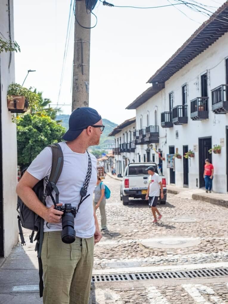 Un homme avec un appareil photo debout dans une rue pavée de Giron.