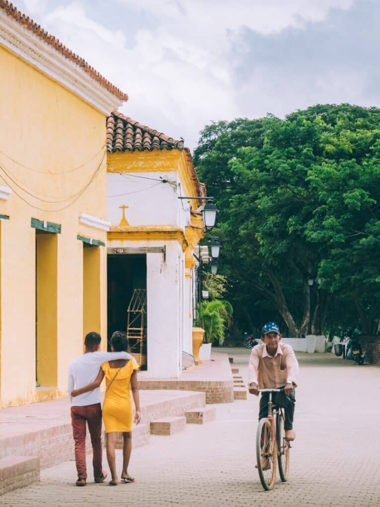 Un couple à bicyclette devant un bâtiment jaune à Mompox.